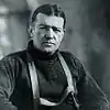 Man wearing a thick jumper and over it suspenders.