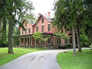 A large brick house surrounded by trees