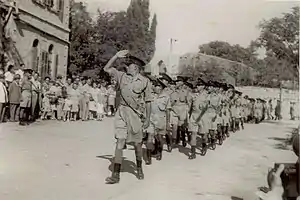 שוטרי ירושלים צועדים בחזית בית הדגל, במהלך טקס השבעתם למשטרת ישראל, 16.8.1948. צועד בראש הסמל חיים תבורי, לימים המפכ"ל השישי של משטרת ישראל.